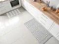 Dwa dywaniki na jasnej podłodze w kuchni. Jeden w paski, drugi z geometrycznym wzorem. Idealne, by chronić podłogę.