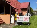 Trzy osoby trzymają baner "Budynek zalegalizowany", symbolizujący jak zrobić odbiór domu po 20 latach.