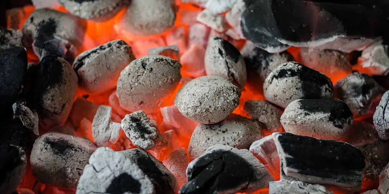 Żarzące się węgle, idealne do grillowania. Pamiętaj, że do kiedy można palić węglem, zależy od lokalnych przepisów i sezonu grzewczego.