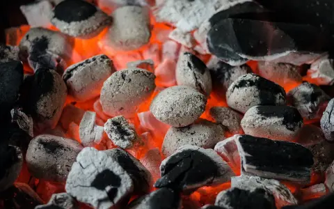 Żarzące się węgle, idealne do grillowania. Pamiętaj, że do kiedy można palić węglem, zależy od lokalnych przepisów i sezonu grzewczego.