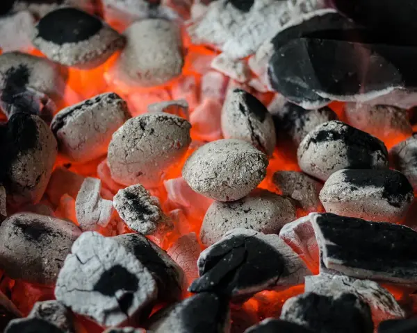 Żarzące się węgle, idealne do grillowania. Pamiętaj, że do kiedy można palić węglem, zależy od lokalnych przepisów i sezonu grzewczego.
