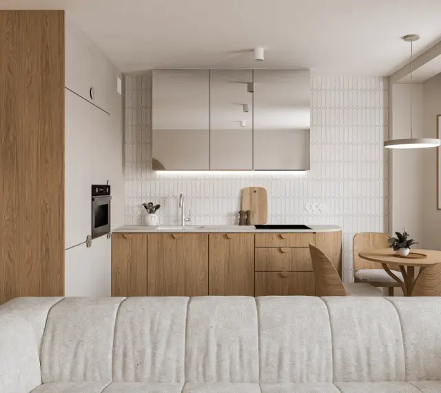 Nowoczesny salon z aneksem kuchennym. Jasne drewno, lustrzane fronty szafek i minimalistyczny design tworzą przytulną atmosferę.