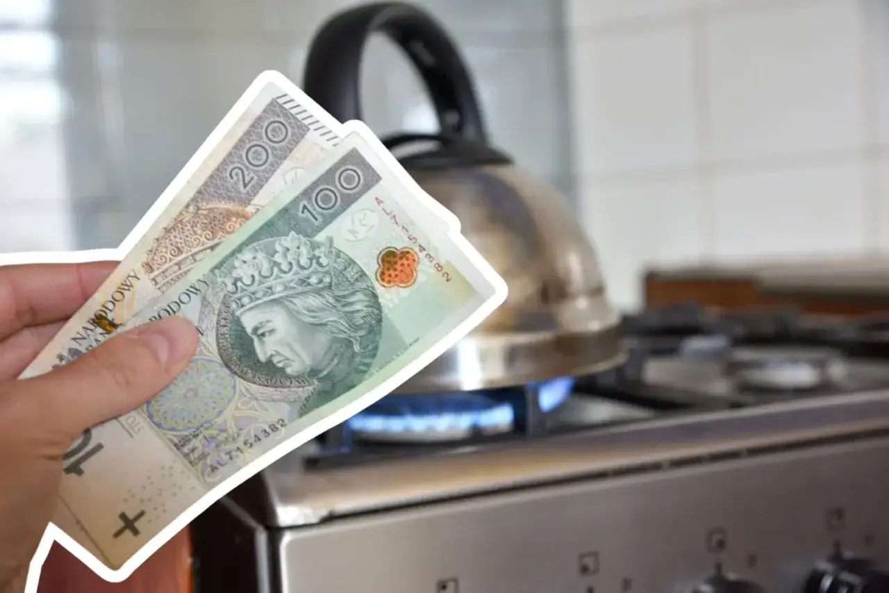 Rachunek za ogrzewanie gazem rośnie. Dłoń trzyma banknoty 100 i 200 zł nad płomieniem gazowym pod czajnikiem.