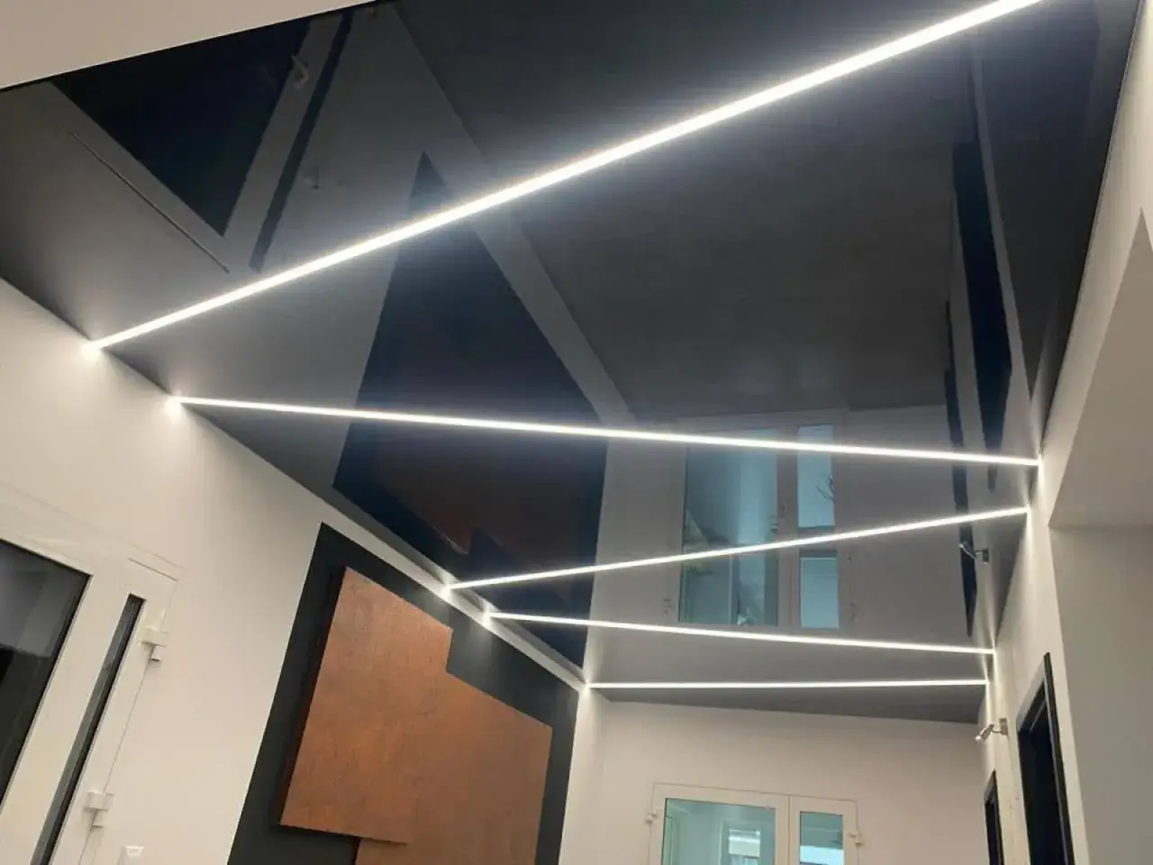 Nowoczesny sufit napinany z oświetleniem LED. Wady montażu widoczne w nierównościach i niedociągnięciach.